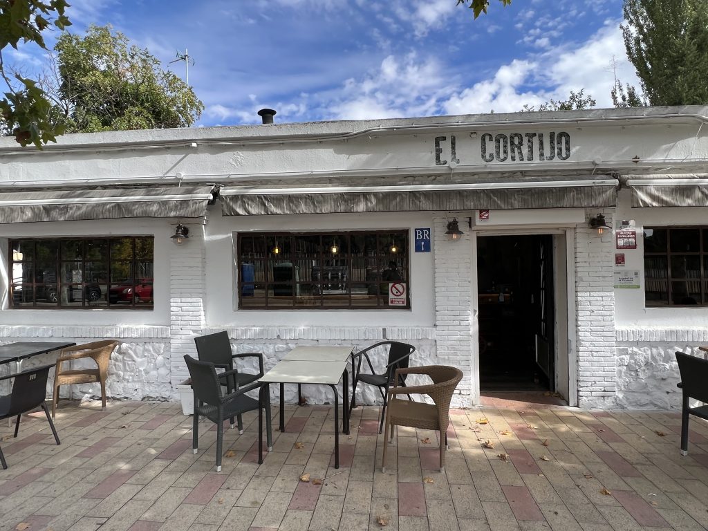 Exterior de restaurante donde vemos entrada y en la acera mesas y sillas