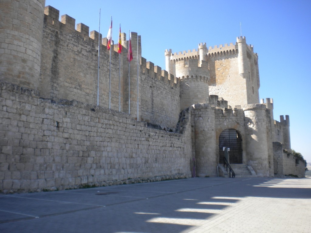 Castillo de piedra donde se ve torre y puerta de acceso