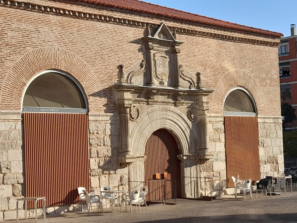 Edificio de ladrillo y piedra con puertas de acceso y ventanas en forma de arco
