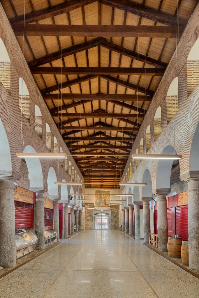 Interior de edificio donde se ven arcos y techo de madera