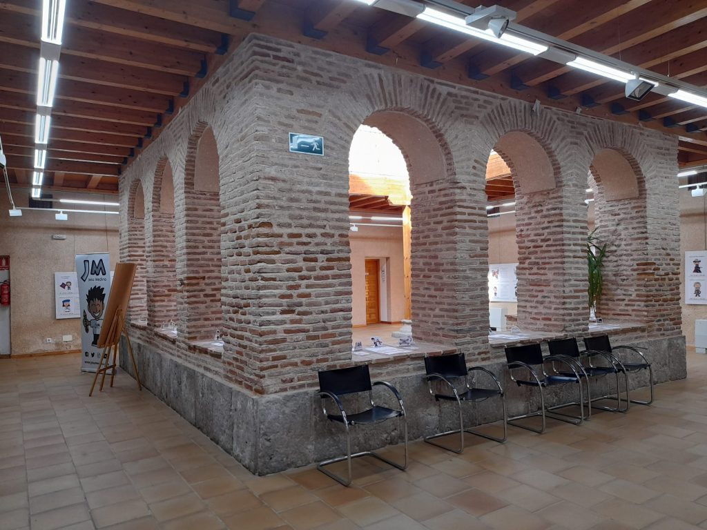 Sala donde se ven arcos de ladrillo que dan a patio interior y sillas