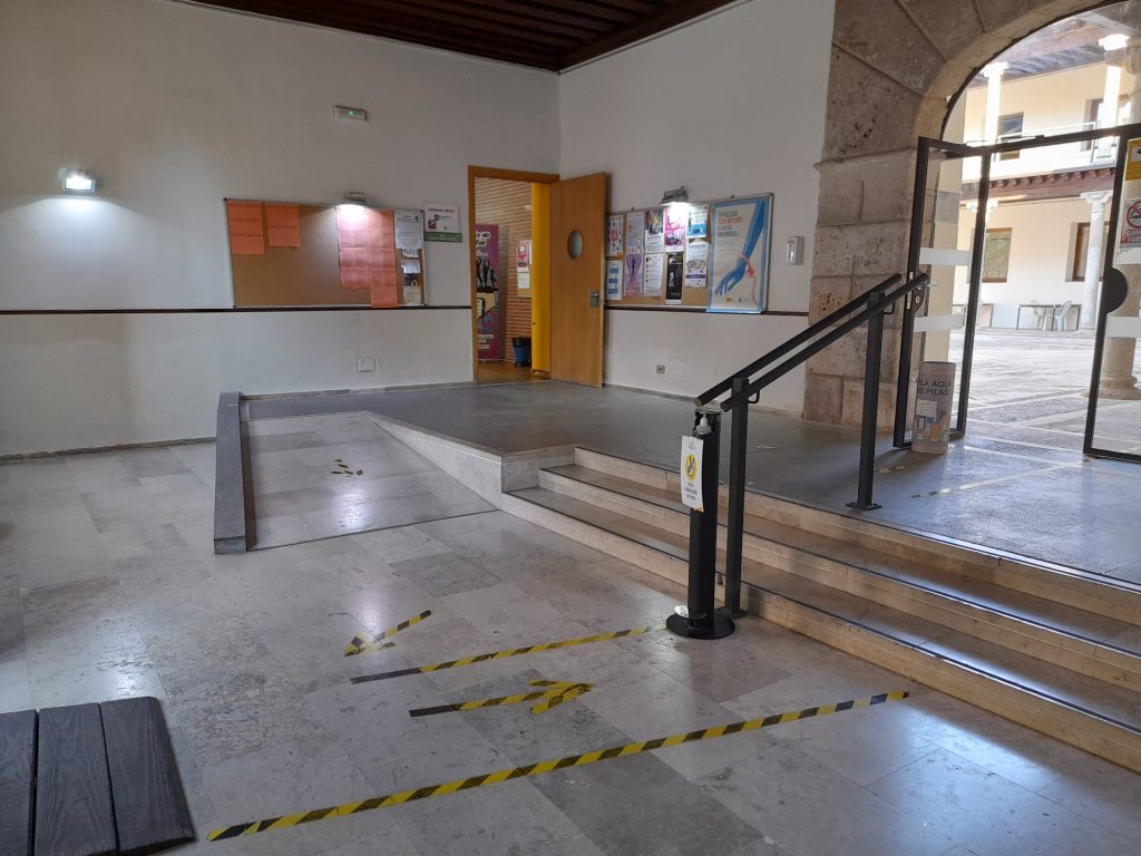 Interior de sala donde se ve acceso de escaleras y rampa para PMR