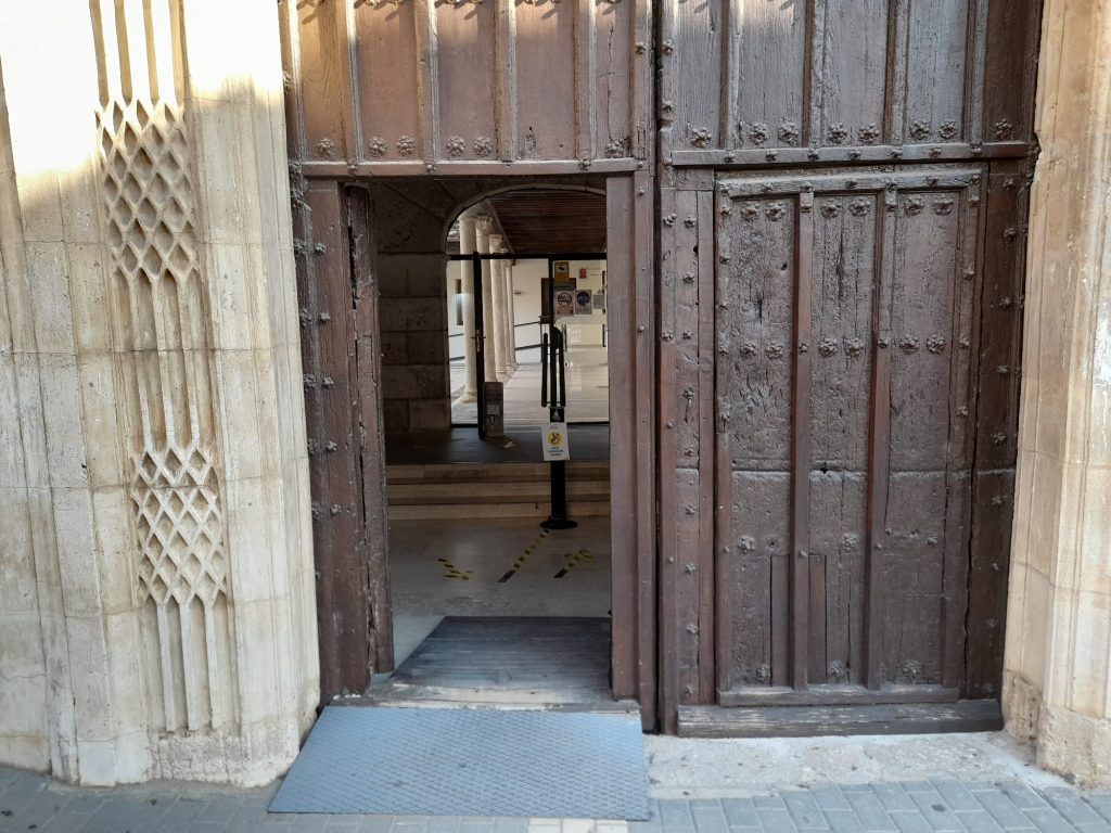 Puerta de madera de acceso a edificio con rampa